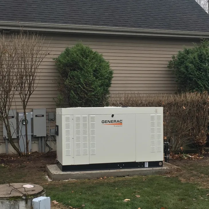 Cream Generac Protector standby generator installed beside a tan-sided home