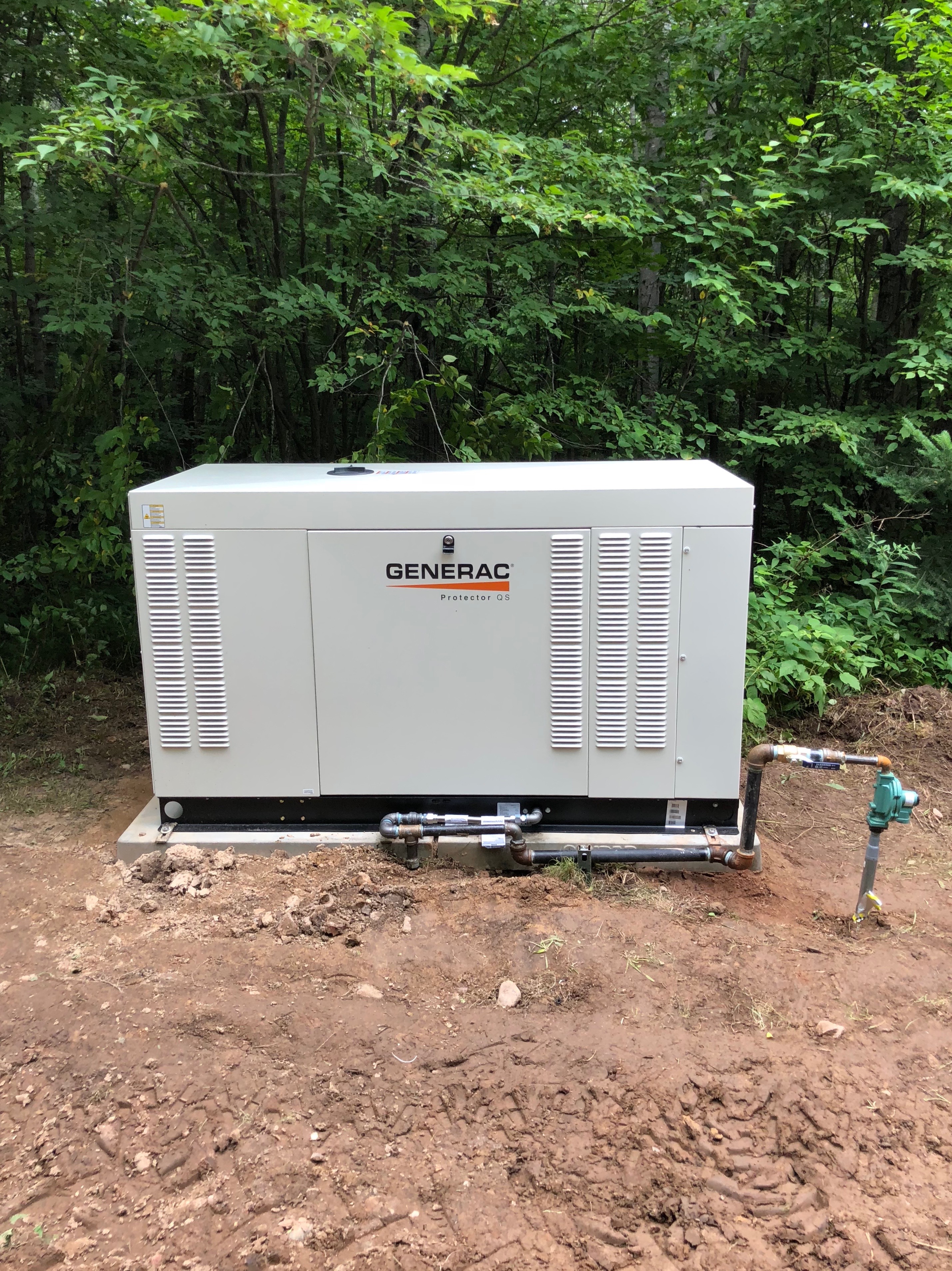 Larger Generac Protector QS liquid-cooled generator installed in the woods