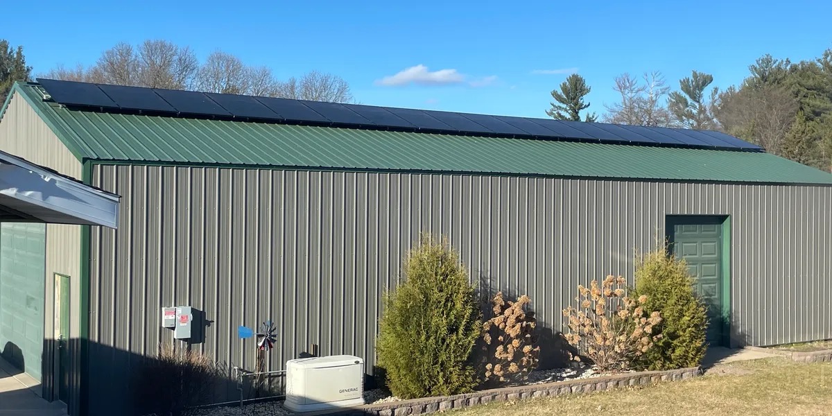Roof-mounted solar array and a Generac standby generator on a steel building