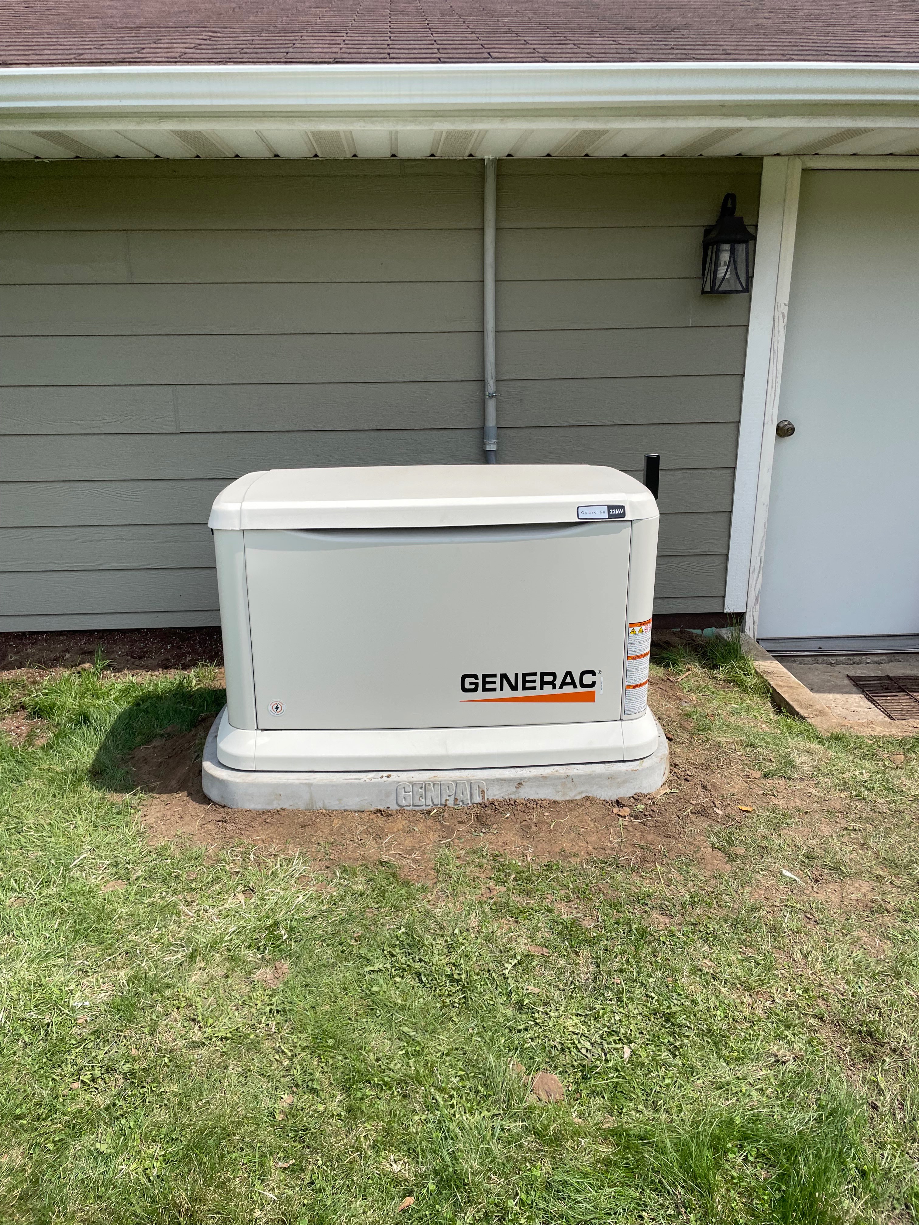 Completed residential Generac Guardian standby generator on a concrete pad